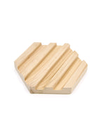 A light natural wood hexagonal soap dish with parallel grooved channels, shown on a plain white background.
